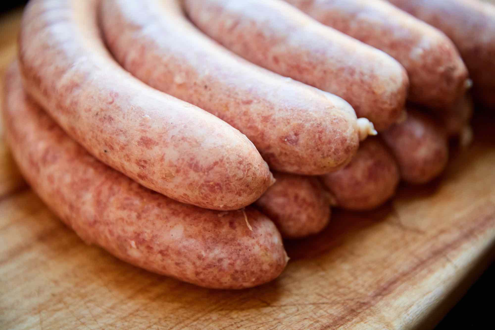 Fresh sausage links on cutting board